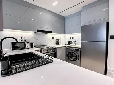 a kitchen with a refrigerator and a dishwasher at Trophy Amazing Burj Khalifa Views from This Stylish Condo in Dubai