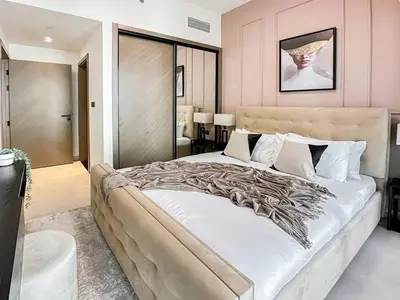 a large bed in a bedroom with pink walls at Trophy Amazing Burj Khalifa Views from This Stylish Condo in Dubai