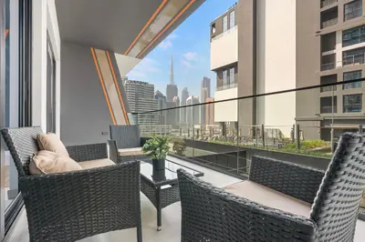 a balcony with chairs and a view of the city at WelHome - Contemporary 1BR in Binghatti Canal & Burj Views in Dubai