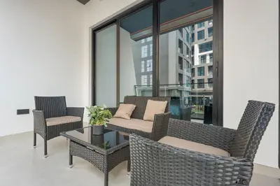a patio with wicker chairs and a table with a couch at WelHome - Contemporary 1BR in Binghatti Canal & Burj Views in Dubai