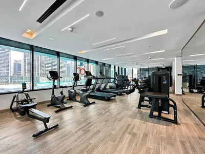 a gym with treadmills and ellipticals in a building at WelHome - Contemporary 1BR in Binghatti Canal & Burj Views in Dubai