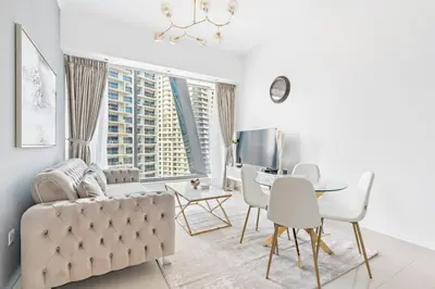 a living room with a couch and a table and chairs at StoneTree - Modern 1BR near Dubai Marina Mall in Dubai