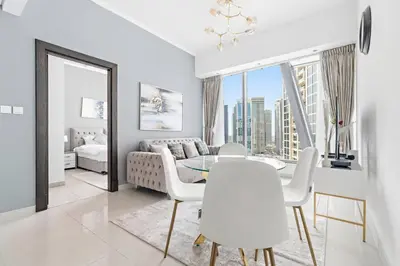 a white living room with a table and a couch at StoneTree - Modern 1BR near Dubai Marina Mall in Dubai