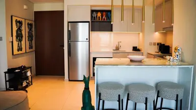 a kitchen with a counter with stools and a refrigerator at VIDA Premier Deluxe - Creek Beach - Beachfront Bliss in Dubai