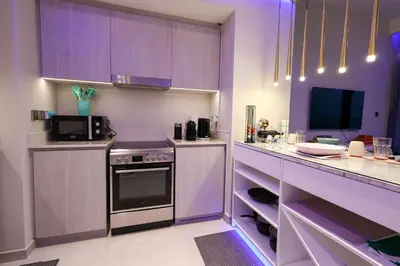 a purple kitchen with a stove and a tv at VIDA Premier Deluxe - Creek Beach - Beachfront Bliss in Dubai