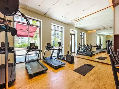 a gym with several treadmills and elliptical machines at VIDA Premier Deluxe - Creek Beach - Beachfront Bliss in Dubai