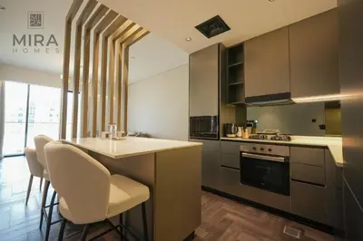 a kitchen with a counter and a table and chairs at Mira Holiday Homes - Newly 1 bedroom with pool access in Dubai