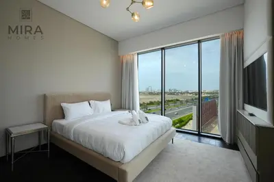 a bedroom with a large bed and a large window at Mira Holiday Homes - Newly 1 bedroom with pool access in Dubai
