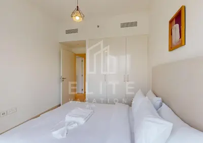 a white bedroom with a bed with white pillows at Walk to Dubai Mall 2 Bed Full Burj Khalifa Views in Dubai