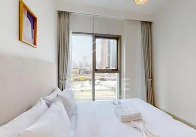 a bedroom with a white bed with a large window at Walk to Dubai Mall 2 Bed Full Burj Khalifa Views in Dubai