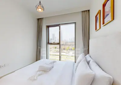a white bedroom with a bed and a window at Walk to Dubai Mall 2 Bed Full Burj Khalifa Views in Dubai