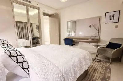 a white bedroom with a bed and a desk at Luxury Paramount Hotel Apt A662 in Dubai
