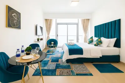 a bedroom with a bed and a table and chairs at Luxurious & Modern Studio in JVC in Dubai