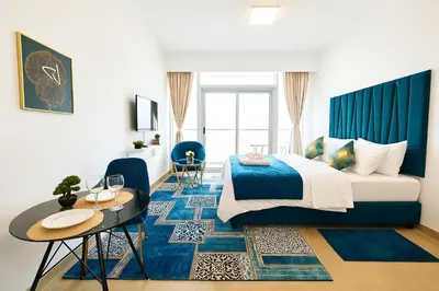 a bedroom with a king sized bed and a table at Luxurious & Modern Studio in JVC in Dubai