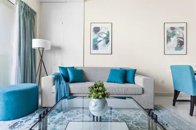 a living room with a couch and a glass table at StoneTree - Damac Heights 1BR apartment in Dubai