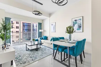 a living room with a couch and a table and chairs at StoneTree - Damac Heights 1BR apartment in Dubai
