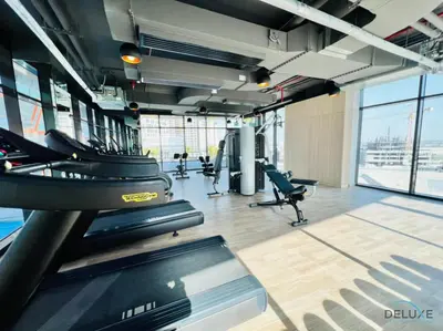 a gym with treadmills and chairs in a building at Soothing 1BR at Binghatti Avenue Al Jaddaf by Deluxe Holiday Homes in Dubai
