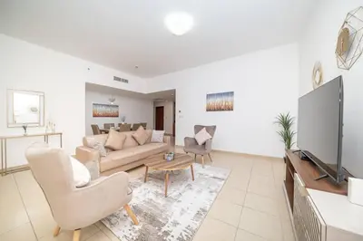a living room with a couch and a tv at StoneTree - Spacious 2 BR near JBR beach in Dubai