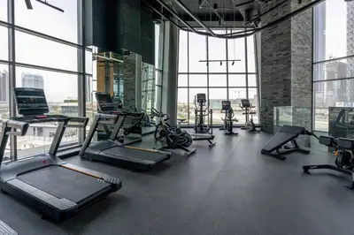 a gym with treadmills and ellipticals in a building at GuestReady - Lux comfort in Business Bay in Dubai