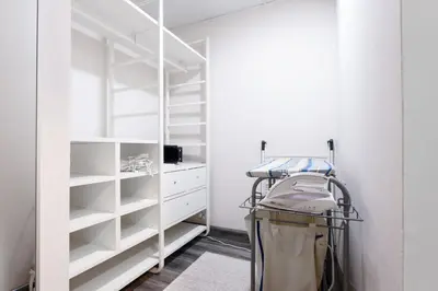 a walk in closet with white shelving at ALiving Elegant & Cozy 1BR I Mazaya 11, Liwan in Dubai