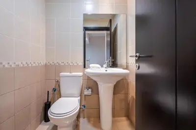 a bathroom with a toilet and a sink at ALiving Elegant & Cozy 1BR I Mazaya 11, Liwan in Dubai