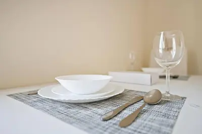 a table with a plate and a bowl and a glass at StoneTree - Cozy Fully-Furnished Studio in JLT in Dubai
