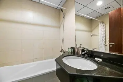 a bathroom with a sink and a bath tub at StoneTree - Cozy Fully-Furnished Studio in JLT in Dubai