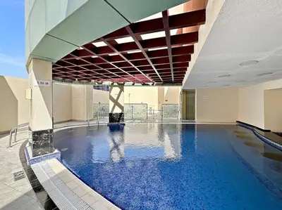 a large swimming pool with blue water in a building at StoneTree - Cozy Fully-Furnished Studio in JLT in Dubai