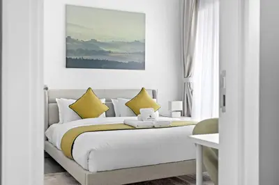 a bedroom with a large bed with yellow pillows at StoneTree - Stylish Apartment with amazing building facilities in Dubai