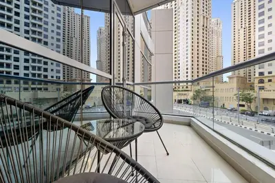 a balcony with two chairs and a view of a city at StoneTree - Stylish Apartment with amazing building facilities in Dubai