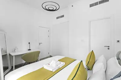 a bedroom with a bed with a sink and a desk at StoneTree - Stylish Apartment with amazing building facilities in Dubai