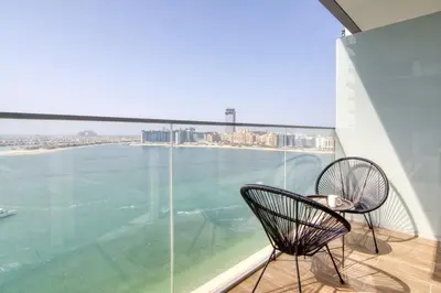 a balcony with two chairs and a view of the water at Sea view 2-Bedroom - Beach Isle in Dubai