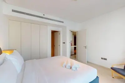 a bedroom with a bed with two towels on it at West Avenue - Chic One Bedroom in Dubai