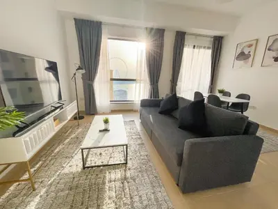 a living room with a couch and a table at Bahar JBR Apartment by HAPPY SEASON in Dubai