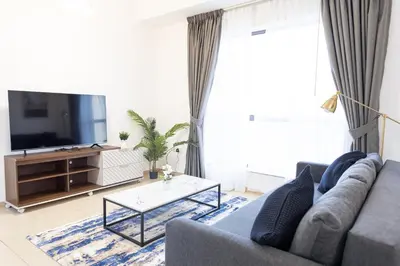 a living room with a blue couch and a tv at Bahar JBR Apartment by HAPPY SEASON in Dubai