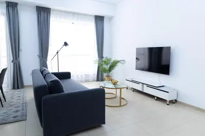 a living room with a blue couch and a tv at Bahar JBR Apartment by HAPPY SEASON in Dubai