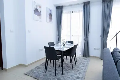 a dining room with a table and chairs and a couch at Bahar JBR Apartment by HAPPY SEASON in Dubai