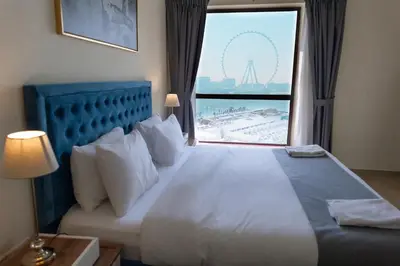 a bedroom with a large bed with a view of the wheel at BAHAR apartments on JBR by HAPPY SEASON in Dubai