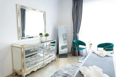 a dressing table with a mirror and green chairs in a room at SHAMS 2 bedrooms apartment on JBR by HAPPY SEASON in Dubai