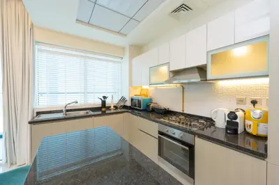 a kitchen with a sink and a stove top oven at FAM Living - Bayz Tower by Danube - Business Bay in Dubai