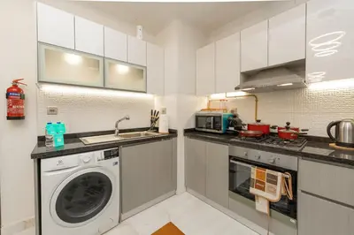 a kitchen with a washing machine and a sink at FAM Living - Bayz Tower by Danube - Business Bay in Dubai