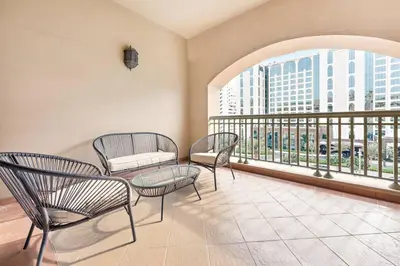 a room with chairs and a table and a balcony at StoneTree - 1BR apartment with Beach Access Fairmont in Palm Jumeirah in Dubai