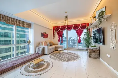 a living room with a couch and a large window at Lake Terrace I JLT I 1 Bedroom Apartment in Dubai