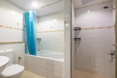 a bathroom with a shower and a toilet and a tub at Lake Terrace I JLT I 1 Bedroom Apartment in Dubai