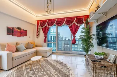a living room with a couch and a large window at Lake Terrace I JLT I 1 Bedroom Apartment in Dubai
