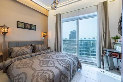 a bedroom with a bed and a large window at Lake Terrace I JLT I 1 Bedroom Apartment in Dubai