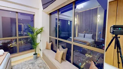 a room with a large window with a couch and a bed at Amazing views Dubai eye & Palm in Dubai