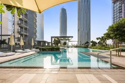 a swimming pool in a city with tall buildings at StoneTree - Elegant 1BR in amazing community in Dubai