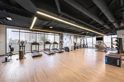 a gym with a wooden floor and a large window at StoneTree - Elegant 1BR in amazing community in Dubai