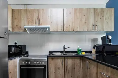 a kitchen with wooden cabinets and a sink at Tranquil Retreat With Epic Marina View in Dubai